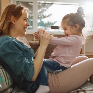 Kvinde sidder med lille pige på skødet