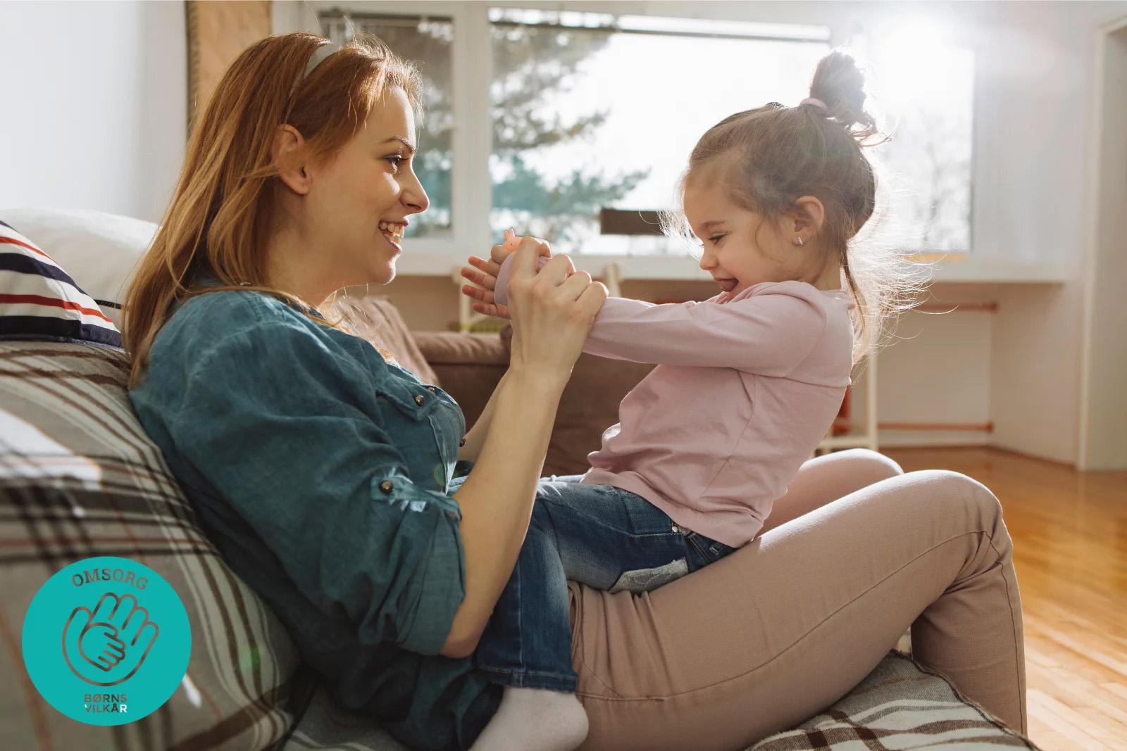 Kvinde sidder med lille pige på skødet