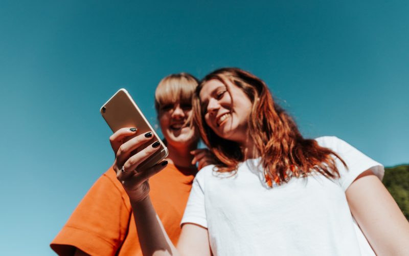 To piger kigger på en telefon sammen
