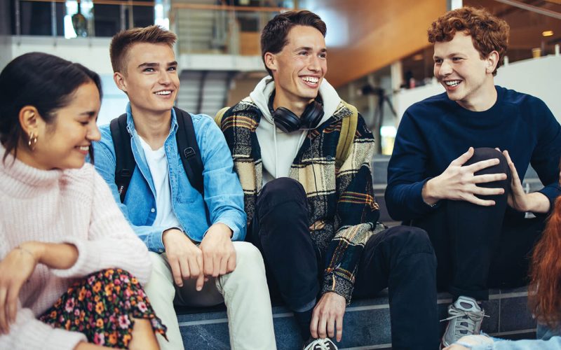 Fem unge sidder på en trappe