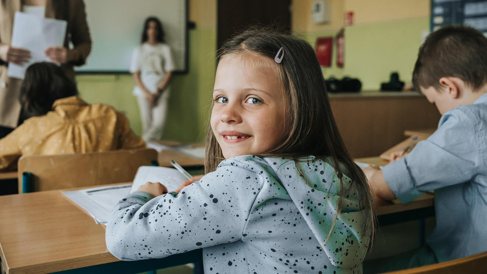 Pige kigger over skulderen i et klasselokale