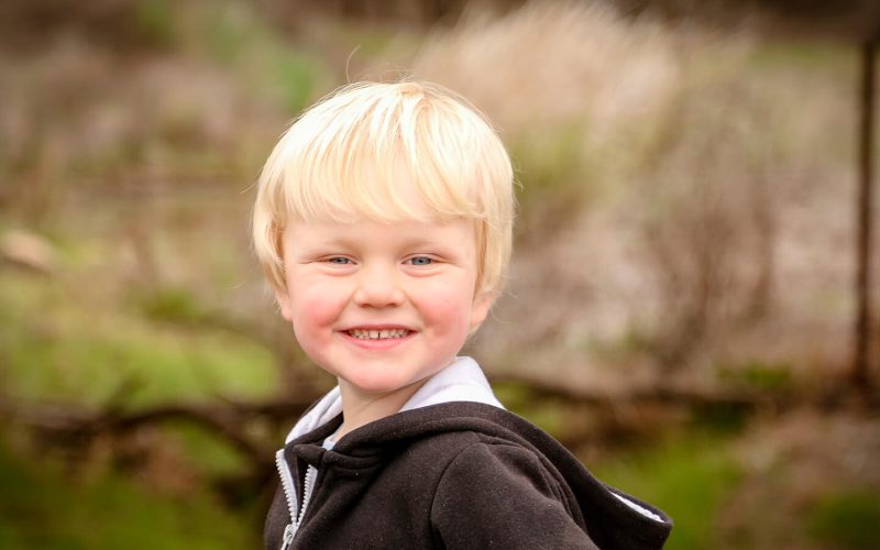 Blond dreng kigger til siden og smiler