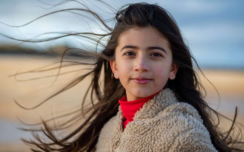 Mørkhåret pige står foran en eng