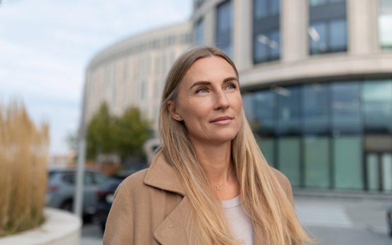 Blond kvinde står foran bygning