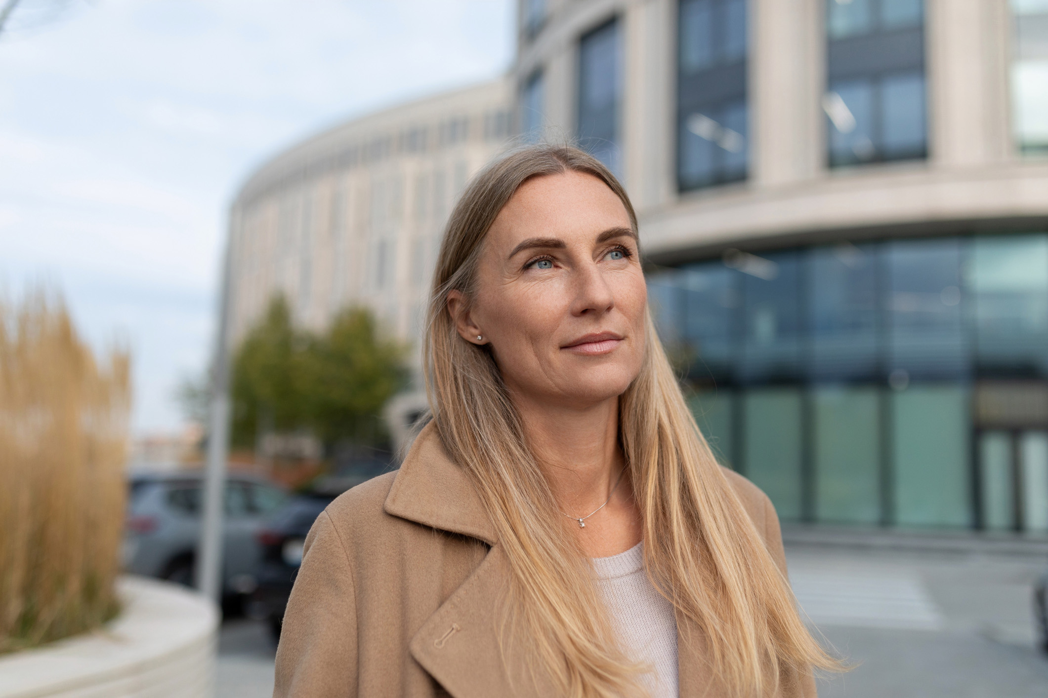 Blond kvinde står foran bygning