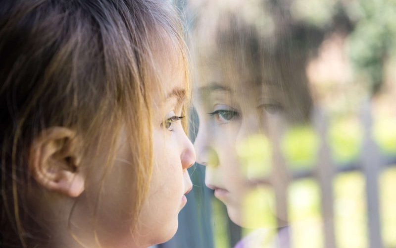 Pige kigger ud af et vindue